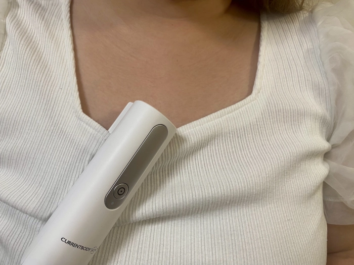 服に引っ掛けたカレントボディの充電器